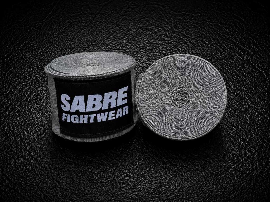 Roll of gray boxing hand wraps with Sabre Fightwear branding on a black background